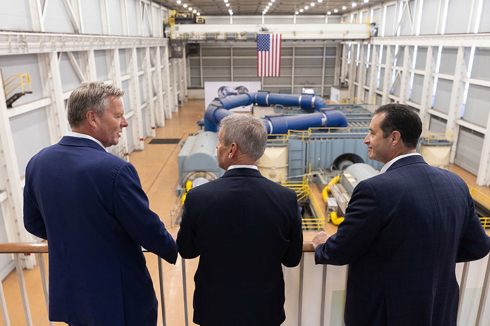 three men looking over stellarator from balcony photo
